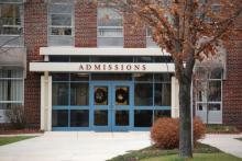 Exterior of an admissions building, marked Admissions above a blue door